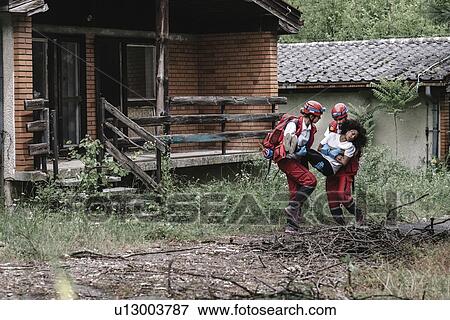Rescue team evacuating woman from house View Large Photo Image Stock Photo - Rescue team evacuating woman from house. Fotosearch