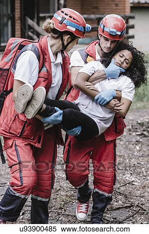 Stock Photography - Rescue team evacuating woman from house. Fotosearch