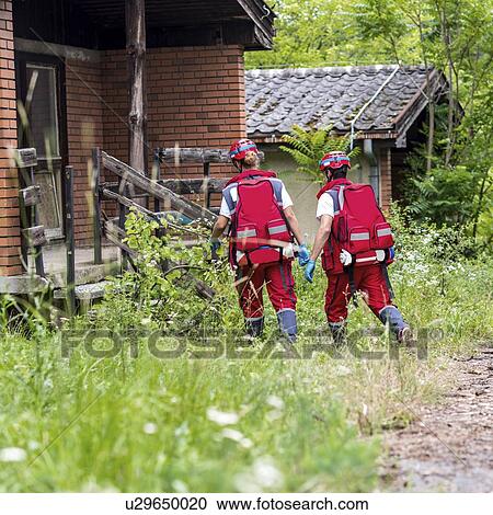 Stock Image - Rescue team helping injured woman. Fotosearch