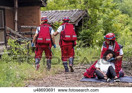 Rescue team helping injured woman View Large Photo Image Stock Image - Rescue team helping injured woman. Fotosearch