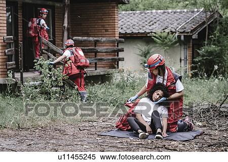 Stock Photography - Rescue team helping injured woman. Fotosearch