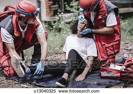 Rescue team helping injured woman View Large Photo Image Stock Photography - Rescue team helping injured woman. Fotosearch