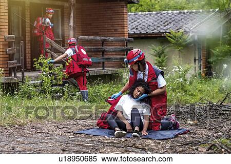 Rescue team helping injured woman View Large Photo Image Stock Photography - Rescue team helping injured woman. Fotosearch