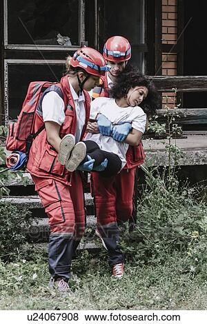 Rescuers evacuating woman View Large Photo Image Stock Photo - Rescuers evacuating woman. Fotosearch