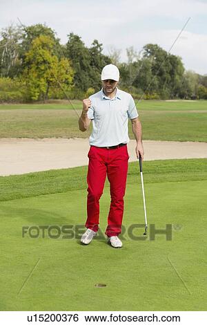 Stock Photograph - Satisfied golfer after successful putting shot. Fotosearch