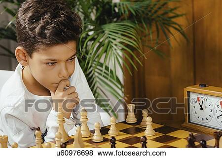 Stock Photo - Schoolboy playing chess. Fotosearch