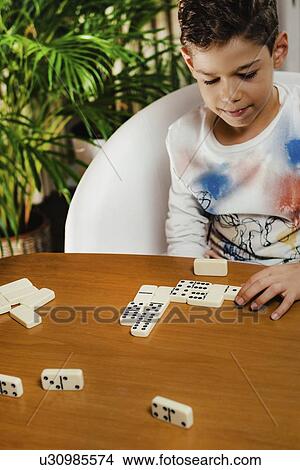 Schoolboy playing dominoes View Large Photo Image Picture - Schoolboy playing dominoes. Fotosearch