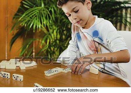 Stock Image - Schoolboy playing dominoes. Fotosearch