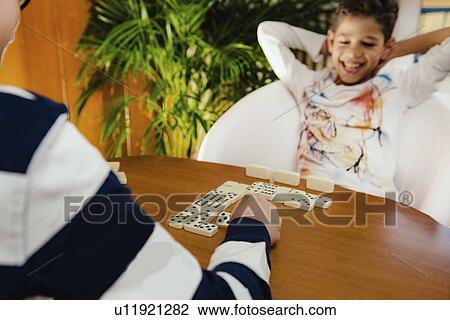 Stock Image - Schoolboys playing dominoes. Fotosearch