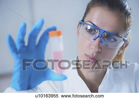 Stock Photography - Scientist holding liquid sample. Fotosearch