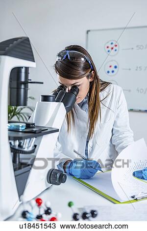 Stock Image - Scientist using microscope. Fotosearch