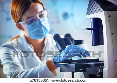 Stock Image - Scientist using microscope. Fotosearch