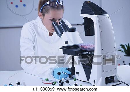 Stock Photo - Scientist using microscope. Fotosearch