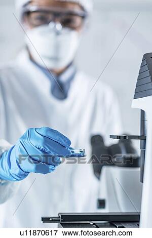 Stock Photo - Scientist using microscope. Fotosearch