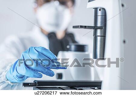 Stock Photo - Scientist using microscope. Fotosearch