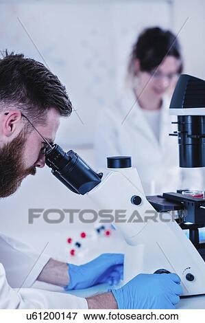 Stock Photo - Scientist using microscope. Fotosearch