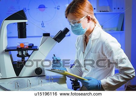 Stock Photograph - Scientist using microscope. Fotosearch