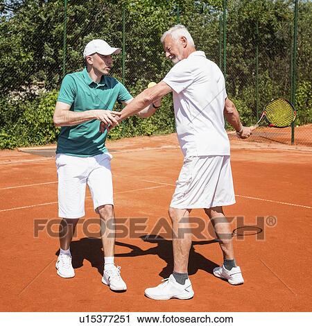Stock Image - Senior man with tennis instructor. Fotosearch