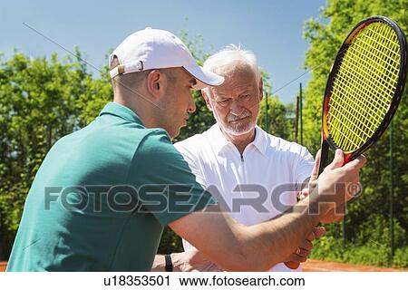 Stock Image - Senior man with tennis instructor. Fotosearch