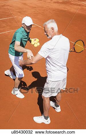 Stock Image - Senior man with tennis instructor. Fotosearch