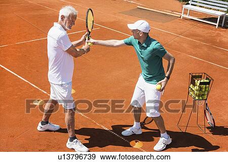 Stock Photo - Senior man with tennis instructor. Fotosearch