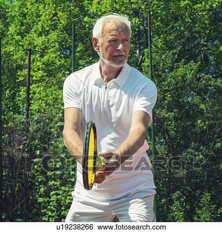 Stock Photograph - Senior tennis player serving. Fotosearch