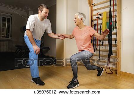 Stock Image - Senior woman doing lunges. Fotosearch
