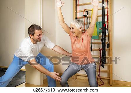 Stock Image - Senior woman doing squats. Fotosearch