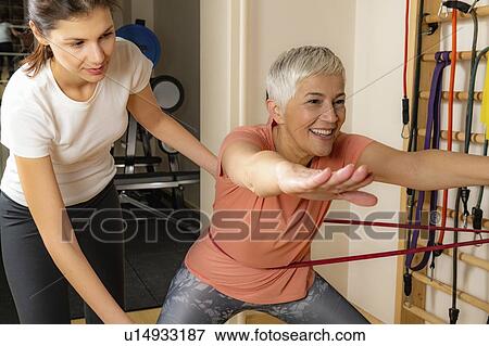 Stock Photo - Senior woman doing squats. Fotosearch