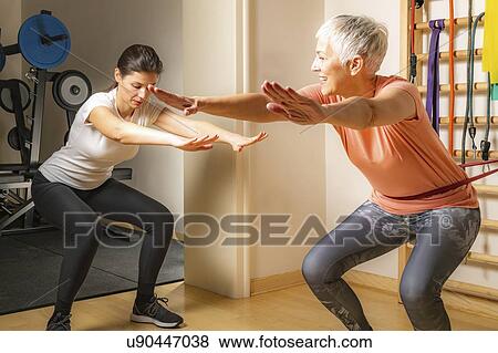 Stock Photo - Senior woman doing squats. Fotosearch