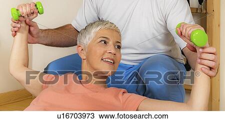 Stock Image - Senior woman exercising on pilates ball. Fotosearch
