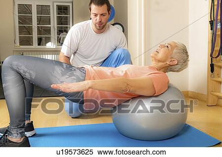 Stock Photography - Senior woman exercising on pilates ball. Fotosearch