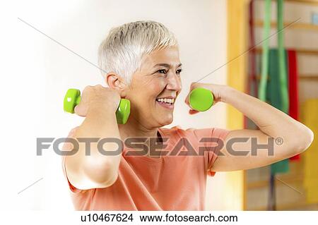 Senior woman exercising with dumbbells View Large Photo Image Picture - Senior woman exercising with dumbbells. Fotosearch