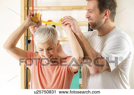 Stock Image - Senior woman exercising with resistance band. Fotosearch