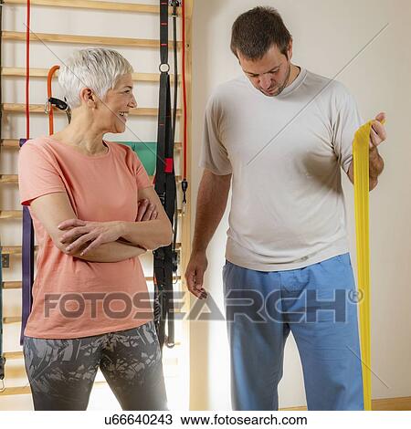 Stock Image - Senior woman exercising with resistance band. Fotosearch