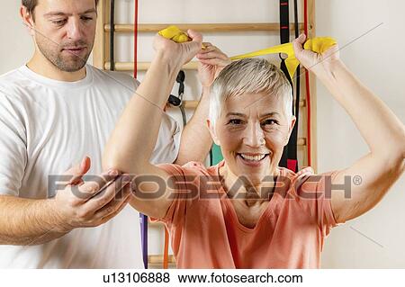 Stock Photo - Senior woman exercising with resistance band. Fotosearch