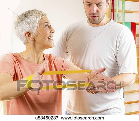 Stock Photo - Senior woman exercising with resistance band. Fotosearch