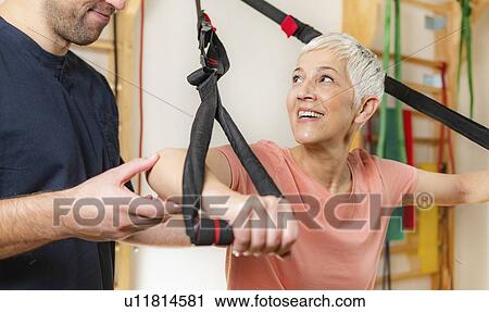 Stock Image - Senior woman with personal trainer. Fotosearch
