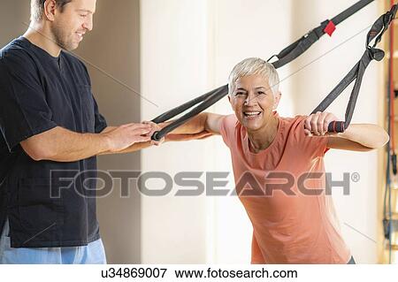 Stock Photo - Senior woman with personal trainer. Fotosearch