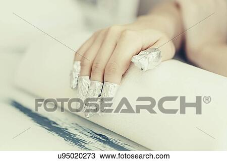 Stock Image - Soaking off gel manicure. Fotosearch