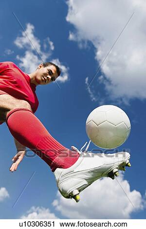Stock Image - Soccer player kicking ball. Fotosearch