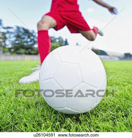 Stock Image - Soccer player kicking ball. Fotosearch