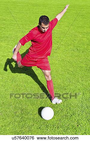 Stock Photograph - Soccer player kicking ball. Fotosearch