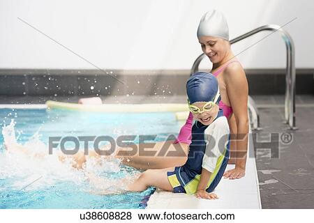 Stock Photo - Splashing in swimming class on the edge of pool. Fotosearch
