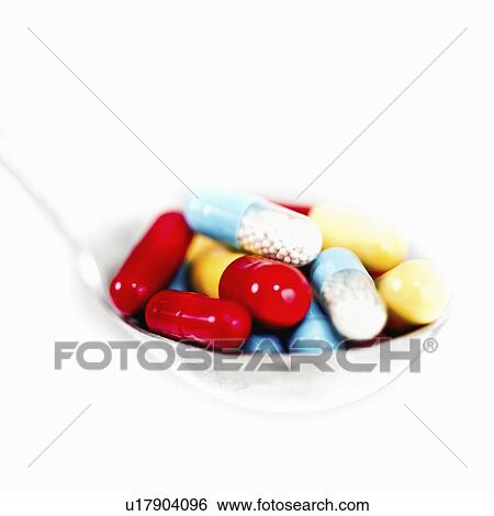 Stock Photograph - Spoonful of multicolored capsules. Fotosearch