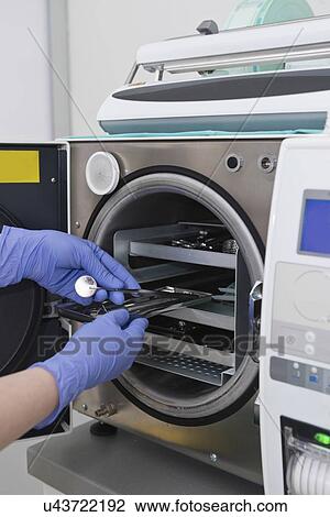 Stock Image - Sterilizing medical instruments in autoclave. Fotosearch