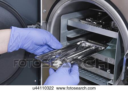 Stock Image - Sterilizing medical instruments in autoclave. Fotosearch