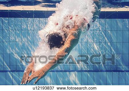 Stock Photo - Swimmer diving into pool. Fotosearch