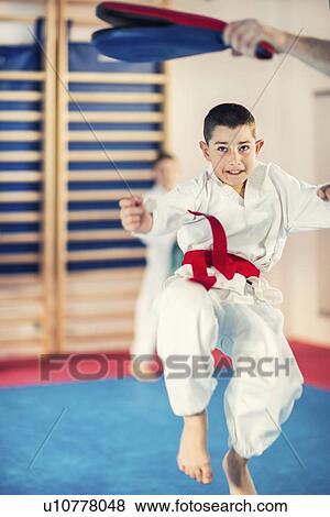 Stock Photo - Taekwondo instructor working with boy. Fotosearch