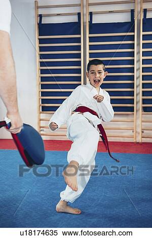 Stock Photography - Taekwondo instructor working with boy. Fotosearch